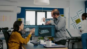 Engineer holding tablet showing to manager 3D gears